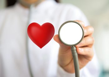 Doctor with stethoscope and red heart  in hand