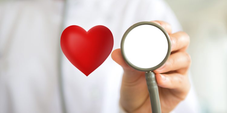 Doctor with stethoscope and red heart  in hand